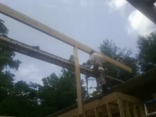 Carpenter setting a ridge beam over a new addition frame — Ice Dam Removal by Roofing Brothers in Armstrong Creek