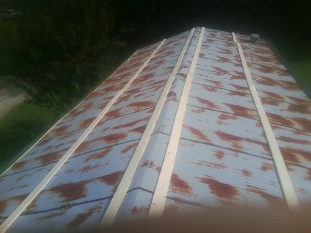 Rusted metal roof panels with new wood purlins before replacement — Storm Damage Roof Repair in Armstrong Creek by Roofing Brothers